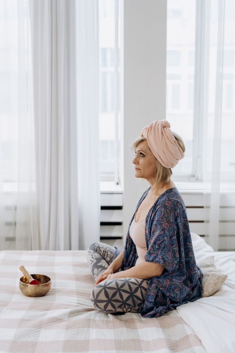 A woman meditates with a Tibetan singing bowl, promoting wellness and relaxation.